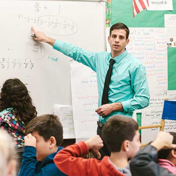 Male teacher pointing to the white board